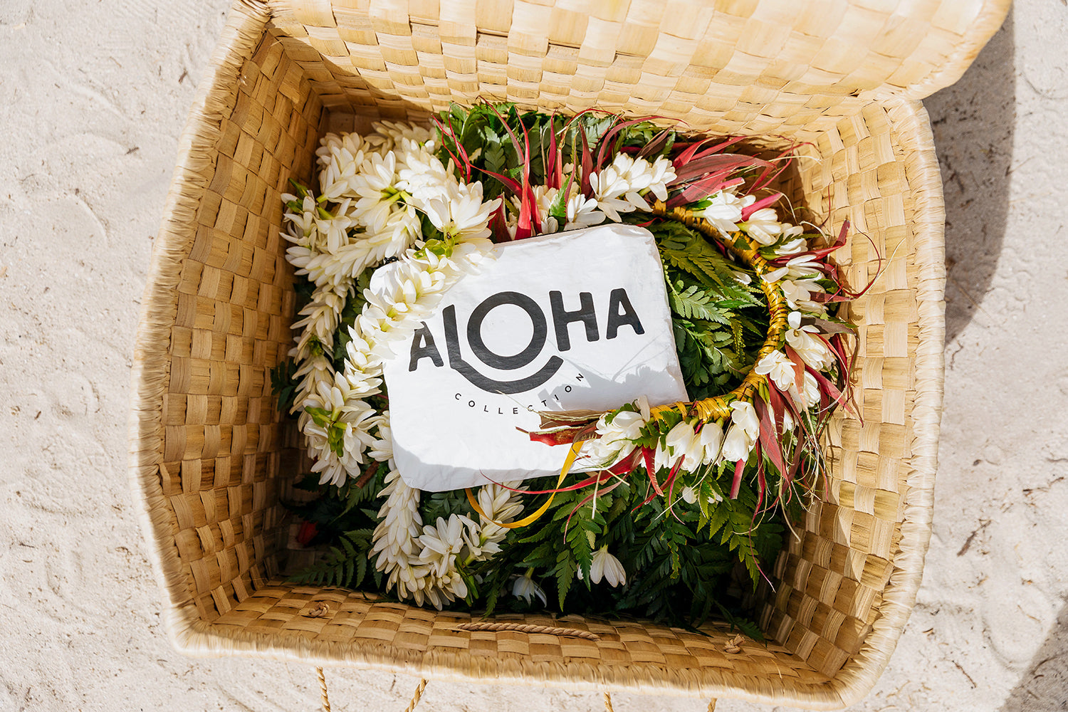 حقيبة Aloha Collection في سلة بها أزهار على الشاطئ